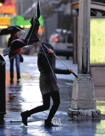 29日，一名市民在曼哈顿时报广场顶着狂风行走。新华社发