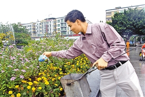 公明广场花坛里的垃圾难清扫，文启坚经常组织办公室工作人员一起捡起花坛里的垃圾。