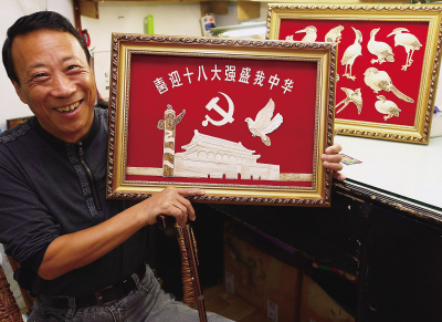 11月3日,肢残人士吴捷在展示笋壳剪贴画.