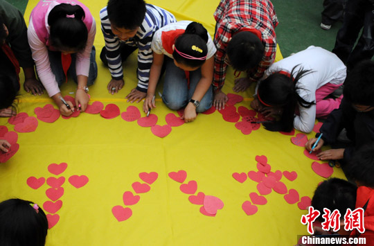 图为翠竹园小学全体师生聚集在操场上，用“爱心贴”的方式表达对祖国的热爱和对十八大的期盼。中新社发 韩苏原 摄