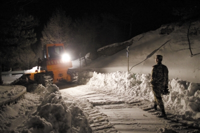 6日晚，武警战士在抢修被大雪封堵的山路，三天前，暴雪将佛爷顶气象站困成“孤岛”。