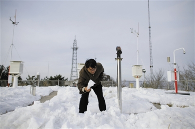 昨日中午，韩文兴正清理被大雪掩埋的碑石。