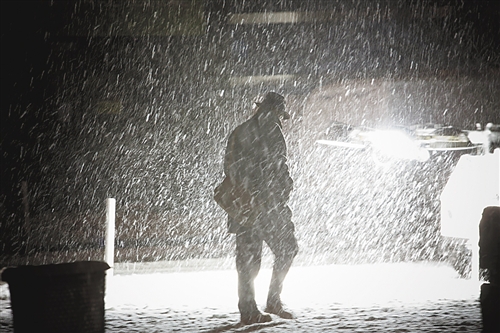 11月7日,在美国纽约金融区,人们冒雨雪前行.