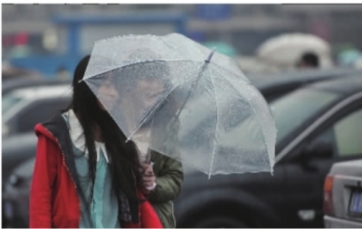 蒙蒙冬雨中,两个美女撑着透明雨伞迎风前进. 记者 李丹 摄