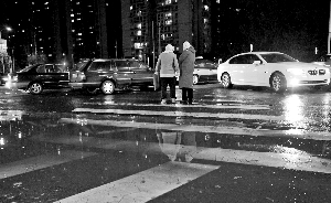 一场雨雪如约而至，路面湿滑，路上的行人和车辆都十分小心。首席摄影记者 蔡代征/摄