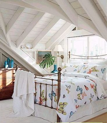 阁楼装修效果图:白色的木条墙壁和屋顶,和明媚的床品
