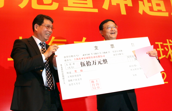 上海体育局局长李毓毅右向徐根宝颁发50万元冲超奖金