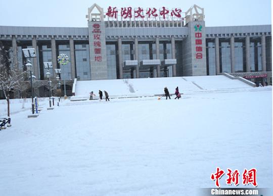 因降雪量大，新疆生产建设兵团农八师一四三团出动推雪机在花园镇坏形路上清雪。王仁斯摄