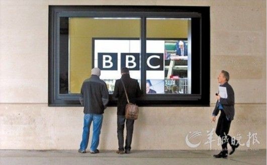 员工在BBC大楼内看关于BBC丑闻的报道。