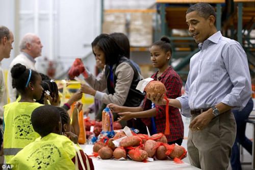 奥巴马与家人在华盛顿特区一家慈善组织给穷人分发食物。