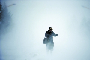 今天早晨,一位女士在东方红的街道上顶着风雪前行.