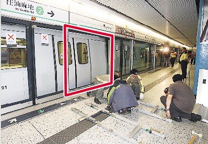 香港九龙塘港铁站2号月台玻璃幕门（红框示）突然爆裂，事后港铁职员马上把已裂开玻璃砸开移走，并在场抢修。来源 香港《明报》