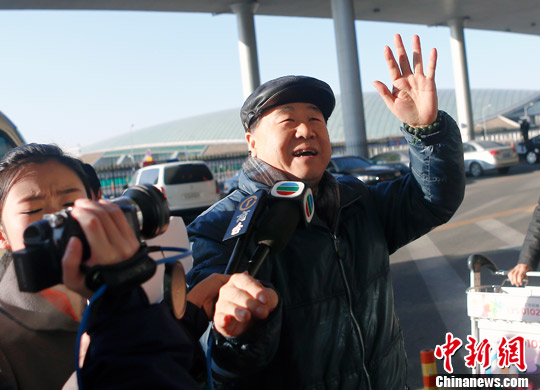 12月5日，莫言从北京首都机场出发启程赴瑞典。图为莫言下车进入机场贵宾室前挥手。中新社发 张浩 摄