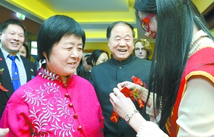 12月8日，在瑞典首都斯德哥尔摩举行的瑞典华人工商界欢迎宴会上，工作人员为2012年诺贝尔文学奖得主、中国作家莫言（中）和夫人杜勤兰（左）配搭胸花。 新华社发