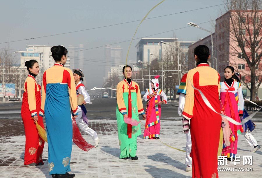 12月12日，在朝鲜首都平壤，身穿民族服装的演员在平壤大剧院门前跳舞庆祝。当日，朝鲜宣布成功发射“光明星3号”卫星后，平壤街头比较平静，偶有庆祝活动举行。新华社记者曾涛摄