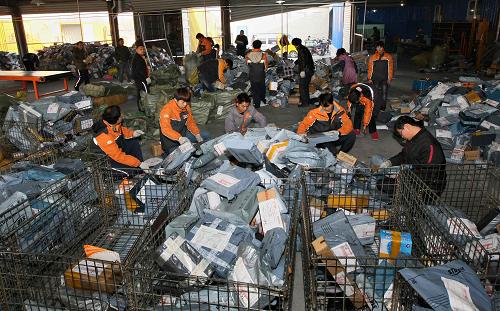 12月12日,快递员在江苏省南通市一家快递公司的派送件现场分拣快件.