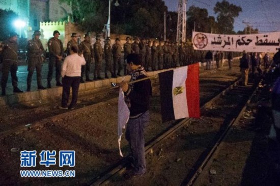 12月11日，在埃及开罗总统府外，埃及反对派抗议者参加集会示威。当日，埃及多地举行集会活动。埃及总统穆尔西坚持本月15日举行宪法草案公投，此举引发了反对派的不满。 新华社记者覃海石摄