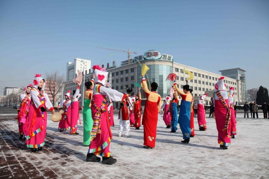 12月12日，在朝鲜首都平壤，身穿民族服装的演员在平壤大剧院门前跳舞庆祝。当日，朝鲜宣布成功发射“光明星3号”卫星后，平壤街头比较平静，偶有庆祝活动举行。新华社记者 张利 摄