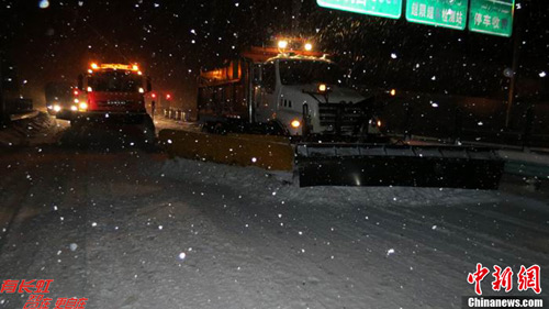 自12日，新疆伊犁赛果高速路遭暴雪袭击，积雪最深达70厘米。图为果子沟公路管理分局工作人员夜间除雪。张可静 摄