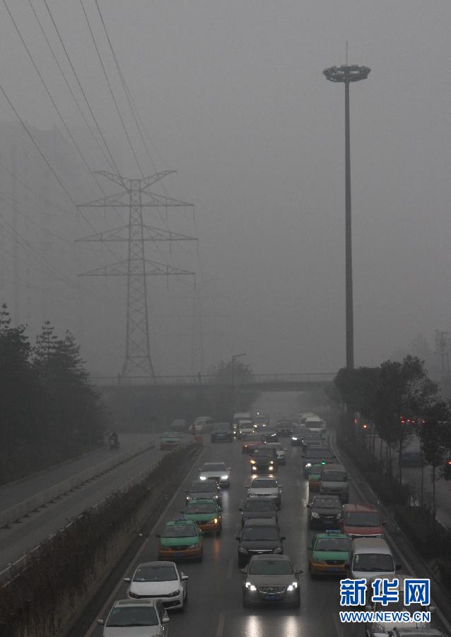12月15日，雨雾笼罩南京，一列火车在雨雾中穿行。当日，南京出现雨雾天气，部分地区能见度不足500米，给城市交通和市民出行带来影响。 新华社发