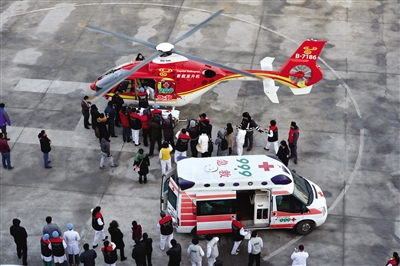 昨日15时54分，急救直升机和救护车在急救中心停机坪交接患儿。新京报记者 吴江 摄