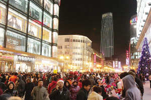 图,,为灯光璀璨,人流如织的滨江道夜色;图为滨江商厦内,消费者摩肩