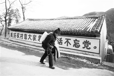 2012年12月31日，河北阜平县顾家台村，村民王德贵从大队领回一袋白面和一件军大衣，往家里走。新京报记者 侯少卿 摄