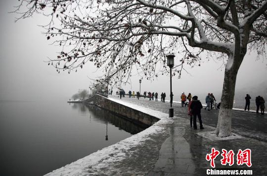 浙江杭州连日降雪，吸引了众多游客前往西湖赏雪。图为杭州西湖著名景点断桥。 李晨韵 摄