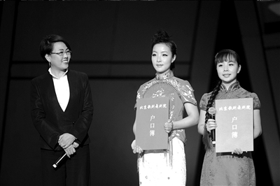 王小妮(中)和姐姐王二妮(右)从北歌院长手中接过"户口簿".