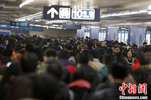 1月6日晚高峰,北京乘客在地铁国贸站1号线和10号线换乘通道前行.