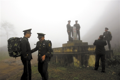 2012年11月25日，田蓬边境检查站管辖的界碑前，刚退伍的战士们拍照留影。第二天他们就要离开边境检查站。