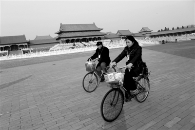 昨日，2名工作人员骑车从故宫内经过。