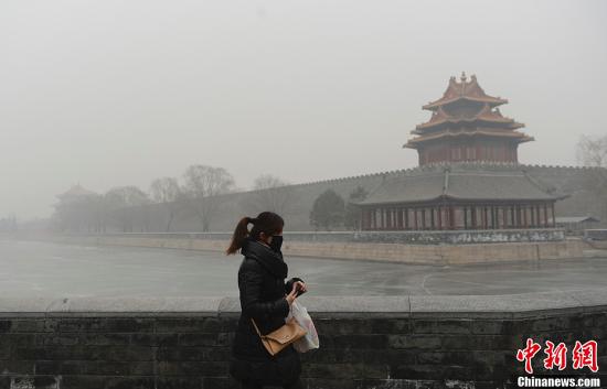 图为1月13日，北京天安门广场区域许多游客带上白色口罩严防空气污染。廖攀 摄