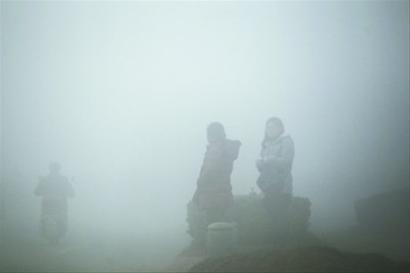 在南京市浦口区，市民在一片浓雾中等车 新华社发