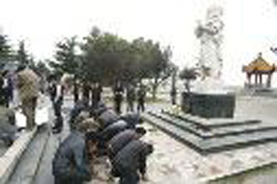 2010年10月11日，河南省郑州市花园口景区入口处，30多名农民工围在一尊河神塑像前跪拜祈求河神显灵，助他们拿到被拖欠的工钱。