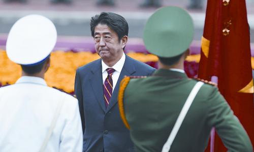 图片说明：日本首相安倍晋三16日开始对越南进行访问。图为安倍在越南河内机场检阅仪仗队。