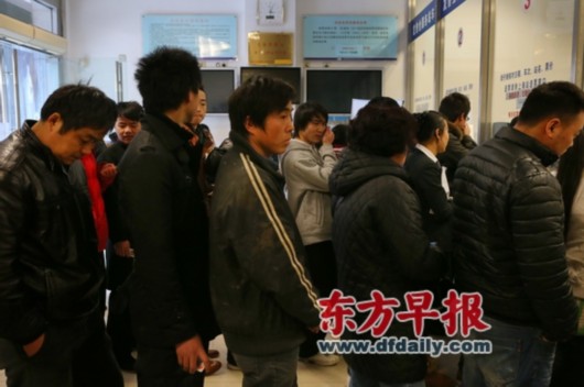 2013年1月17日，上海万航渡路77号，一位务工人员（中）在售票窗口前等待购票，但最终并没有买到回老家长春的车票。
