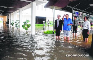 总统尤多约诺左二和外长马蒂左一都卷起裤管，在总统府内涉水视察淹水情况。法新社
