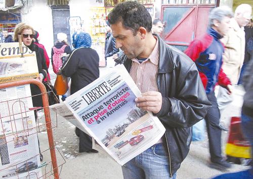 阿尔及利亚当地时间17日，一男子在报刊亭前阅读关于该国天然气田发生人质劫持事件的报道。