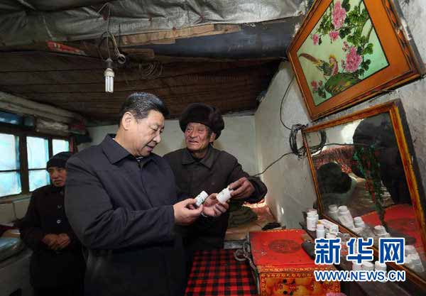 12月29日至30日,中共中央总书记、中央军委主席习近平在河北省阜平县看望慰问困难群众,考察扶贫工作。这是12月30日,习近平在龙泉关镇骆驼湾村困难群众唐荣斌家,详细询问身体有病的唐荣斌(右)日常服药情况。 新华社记者 兰红光