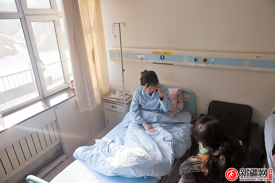 21日,在自治区第一济困医院内科病房,冯燕正在给帮助她的好心人打电话