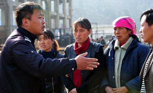 1月23日，一名工作人员在安抚遇难矿工的亲友。新华社记者 杨楹 摄