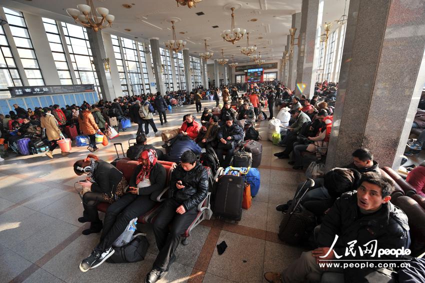 1月26日,北京火车站站台,旅客排队上车。人民