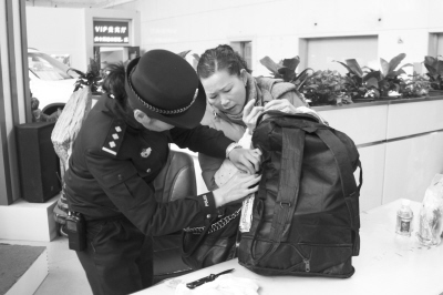 女警察帮助旅客修拉链(图)