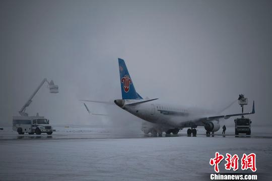 图为30日清晨，南航新疆分公司早出港航班正在进行起飞前的除冰雪作业。杨立山摄
