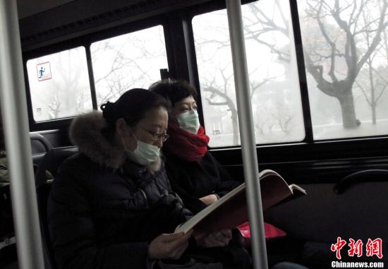 1月31日，北京持续灰霾天气，公交车上市民戴口罩减少被污染。多日持续灰霾天气给市民生活出行带来不便。中新社发 张勤 摄