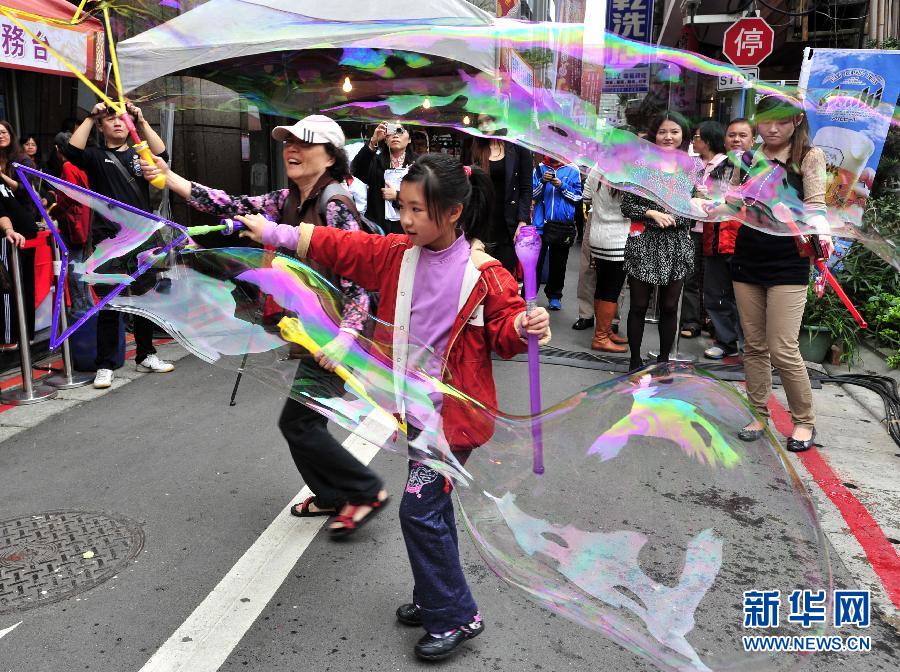 双城徒步商业街,游客在体验创意大型拉泡泡