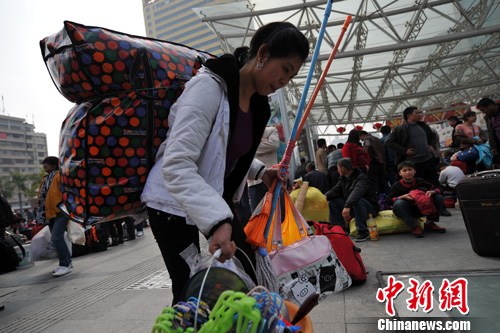 2月2日，在福州火车站，一名旅客背着个大大的包，手上提满了行李准备进站。随着春节的临近，前期购票的旅客进入出行高峰阶段，春运铁路客流开始激增。中新社发 吕明 摄