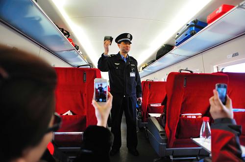 乘警长杨振昌在G604次列车上为旅客表演顺口溜（2月1日摄）。新华社发（王晓 摄）