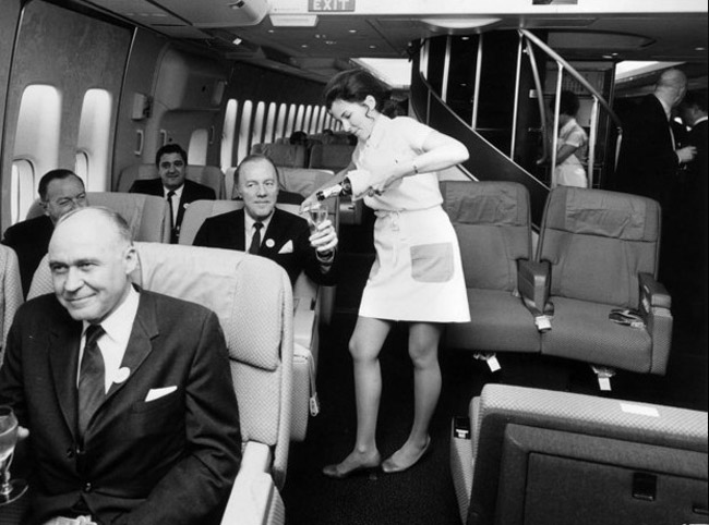0图为1970年泛美航空的空姐为乘客倒饮品.